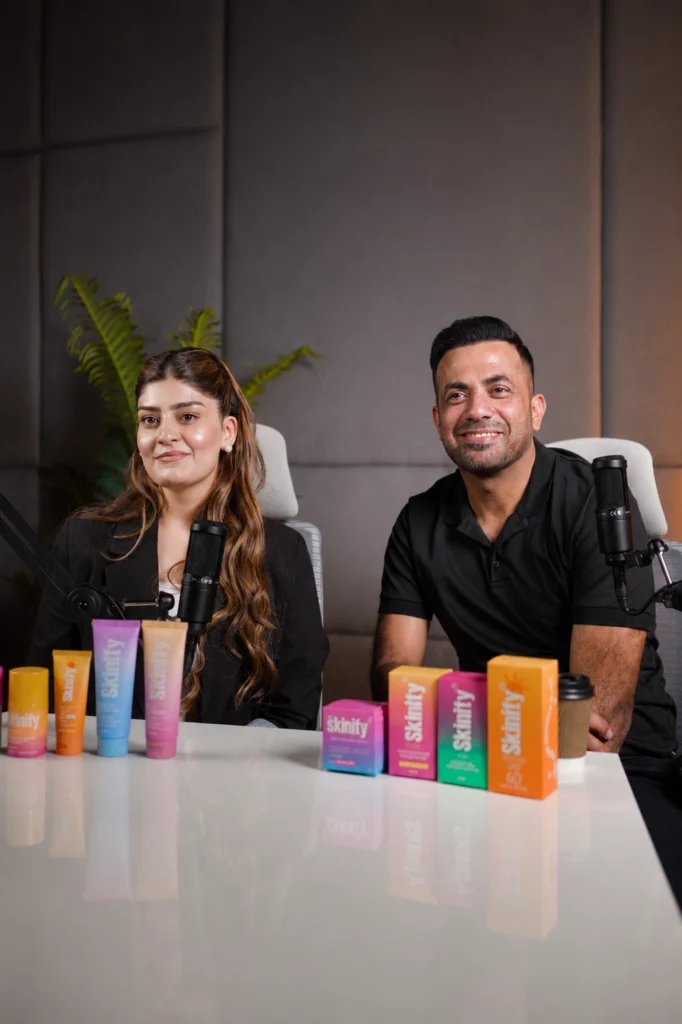 Zainab Wahab and cricketer Wahab Riaz sitting with professional microphones during a video podcast session at a recording studio in Lahore.
